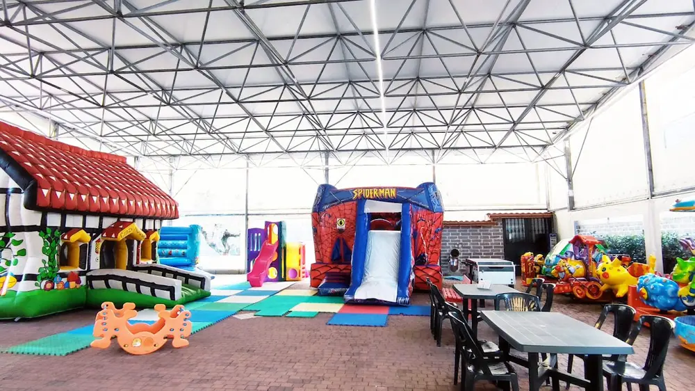 Sala feste con tavoli e area giochi al Play Village